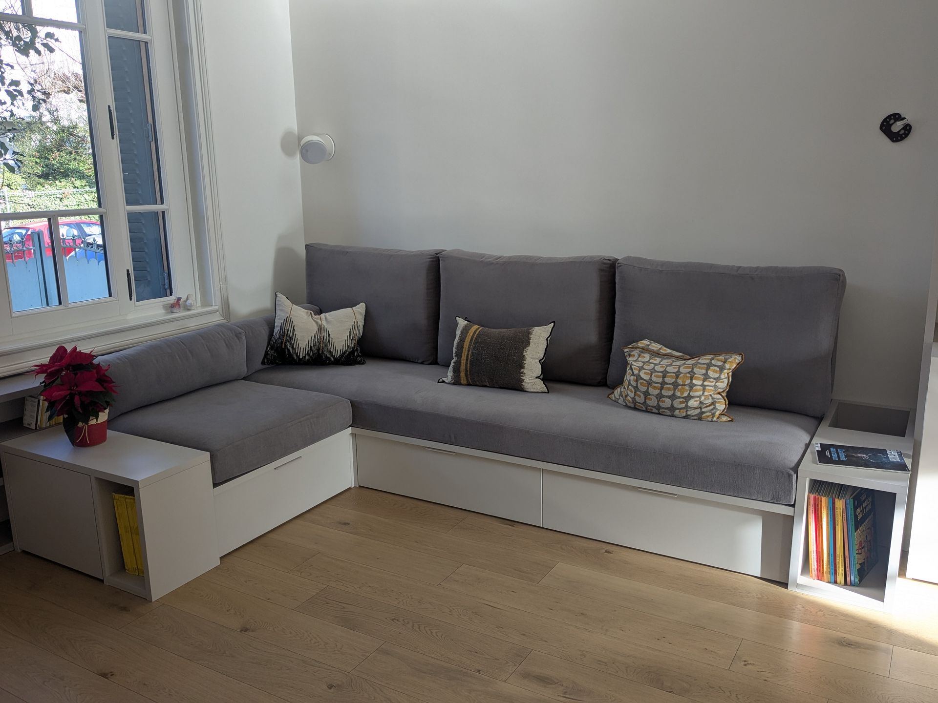 Coussins d'assise et dossiers gris clair sur mesure pour un grand canapé d'angle de salon.