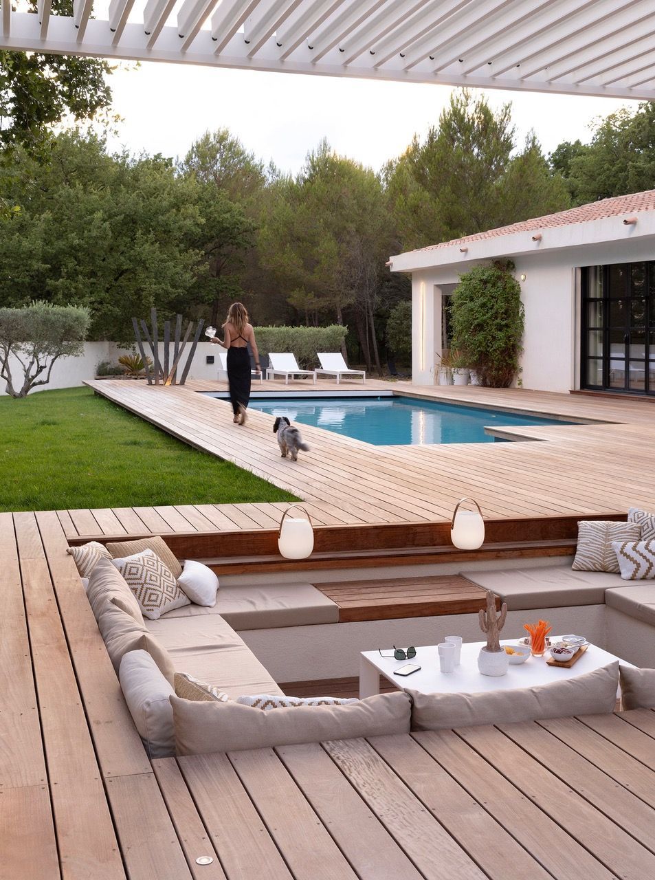 Coussins de canapé d'extérieur sur mesure en tissu gris pour un salon de jardin aménagé en bord de piscine.