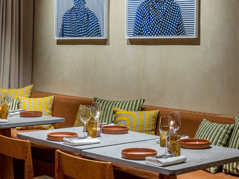 Banquette de restaurant avec coussins d'assise jaunes et rayés sur mesure pour l'aménagement de Tekes.