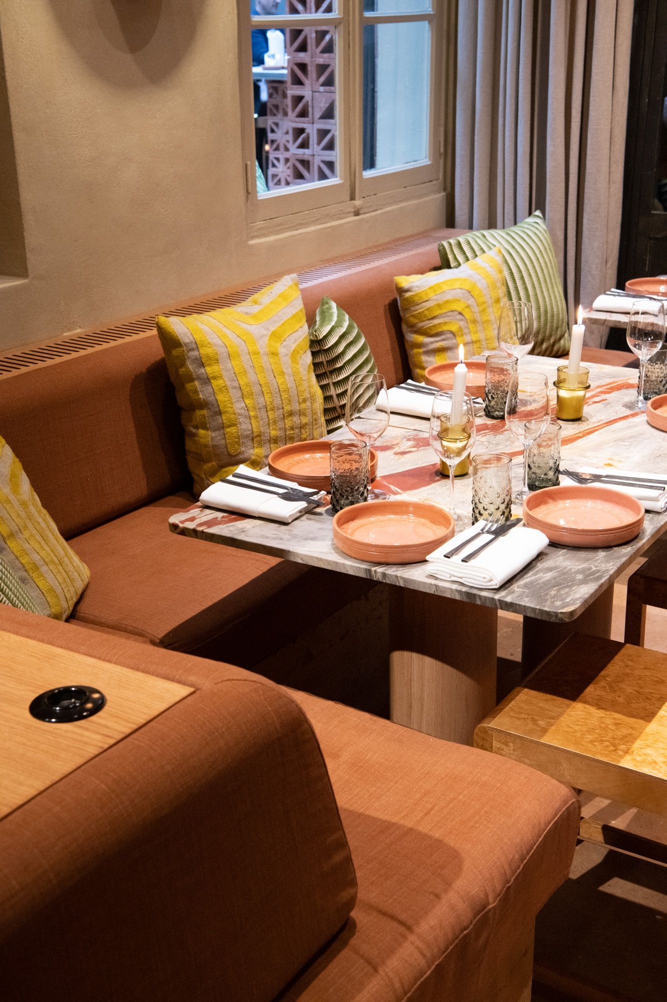 Banquette de restaurant sur mesure couleur terracotta avec coussins de dossier assortis chez Tekes.