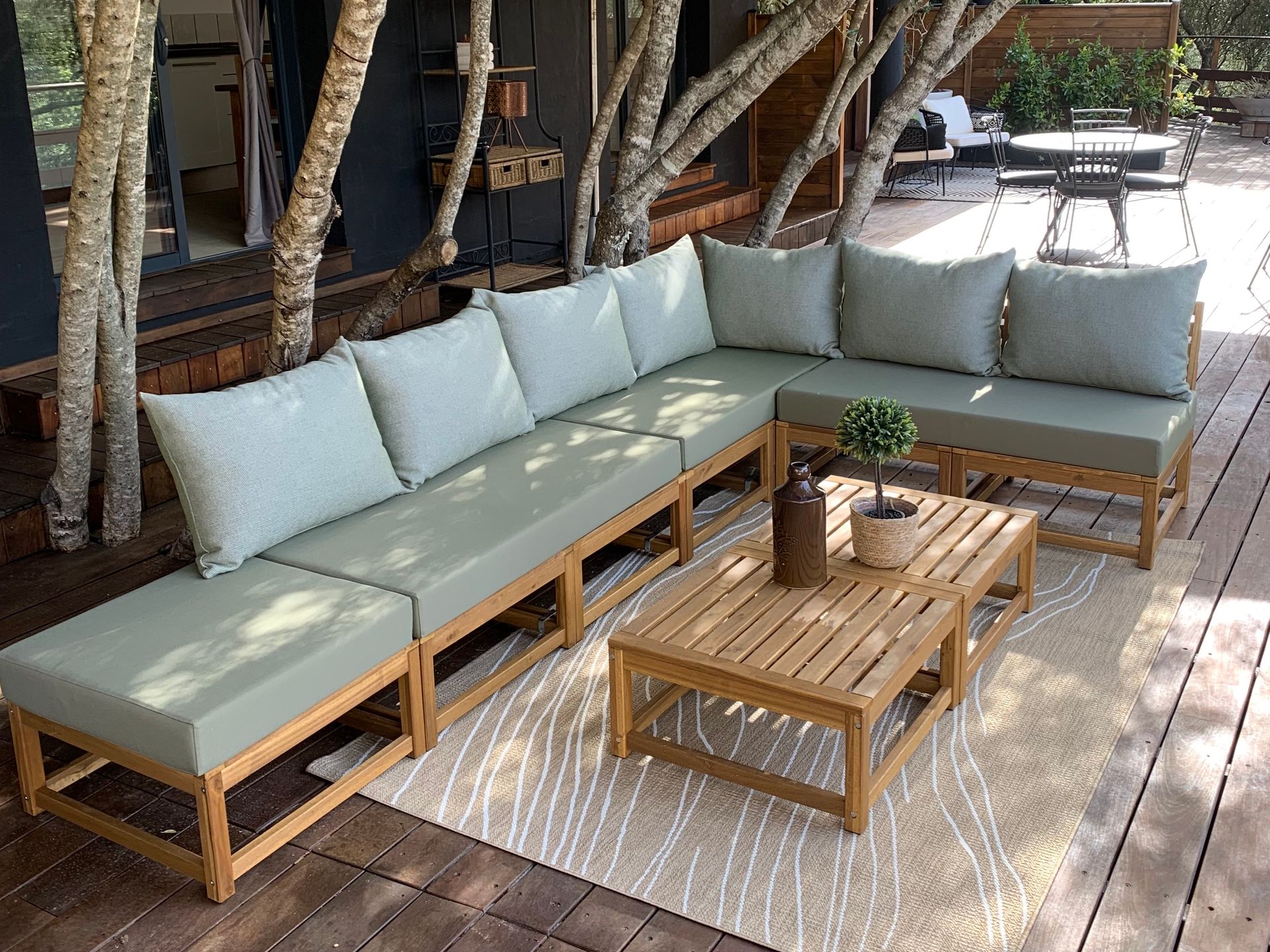Coussins de banquette extérieure sur mesure vert d'eau pour un canapé d'angle en bois massif.