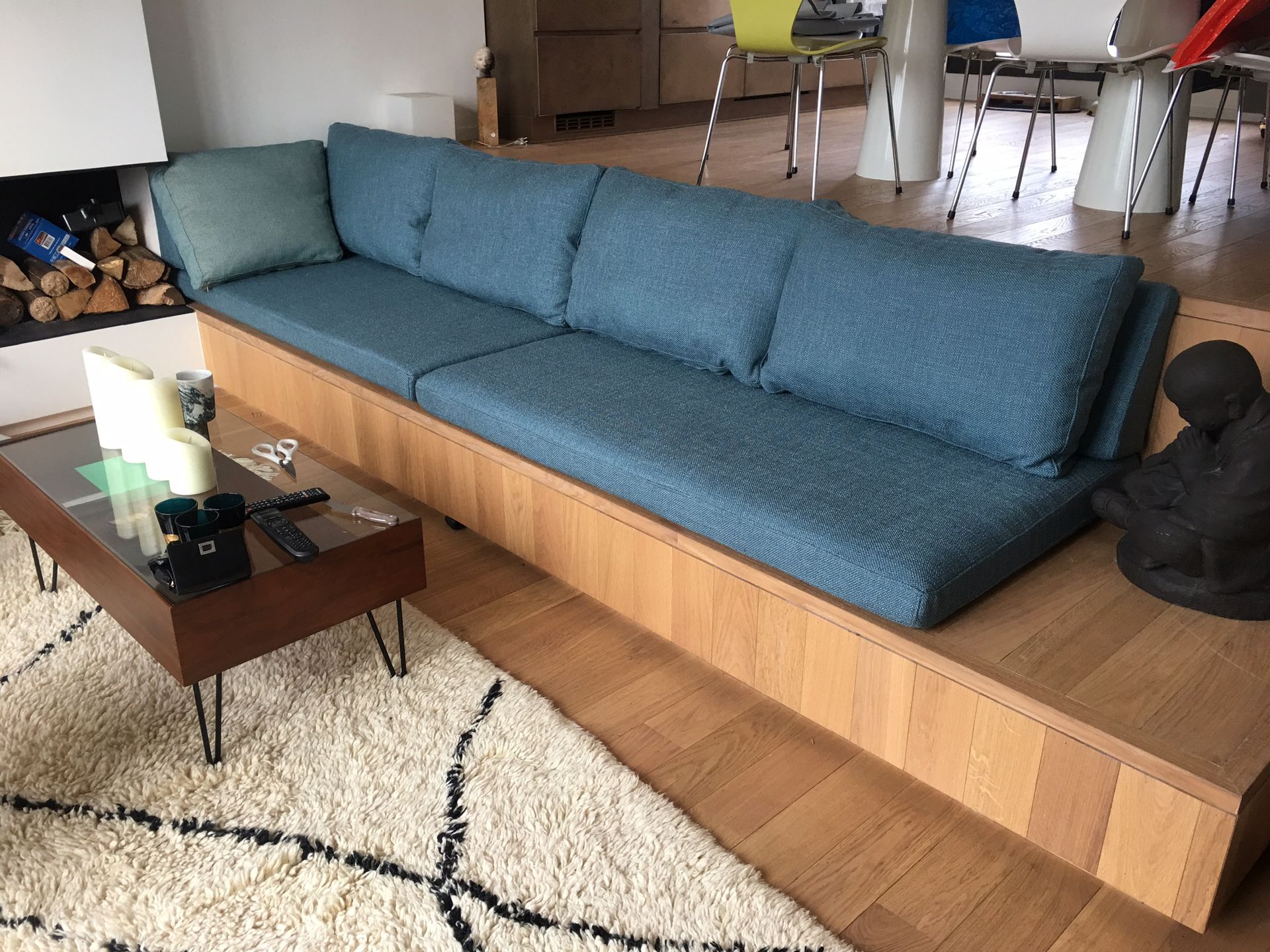 Épais coussin d'assise et dossiers bleus sur mesure pour une grande banquette de salon en bois massif.