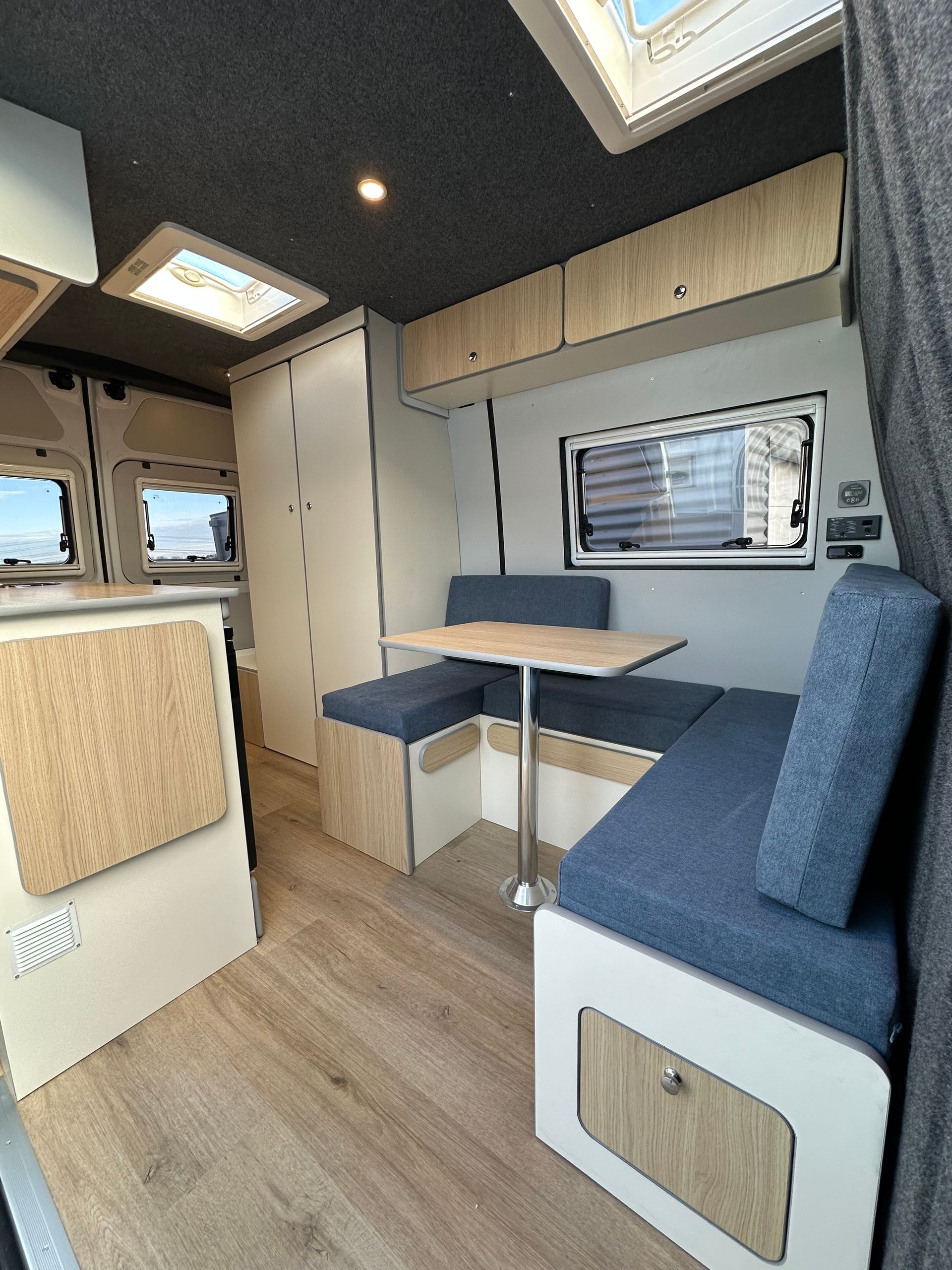 Banquette sur mesure bleu marine dans van aménagé, mobilier bois clair – matelas fourgon Mousse et Confection