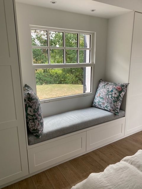 Coussin de banquette sur mesure gris clair pour aménager l'encadrement d'une fenêtre de chambre.