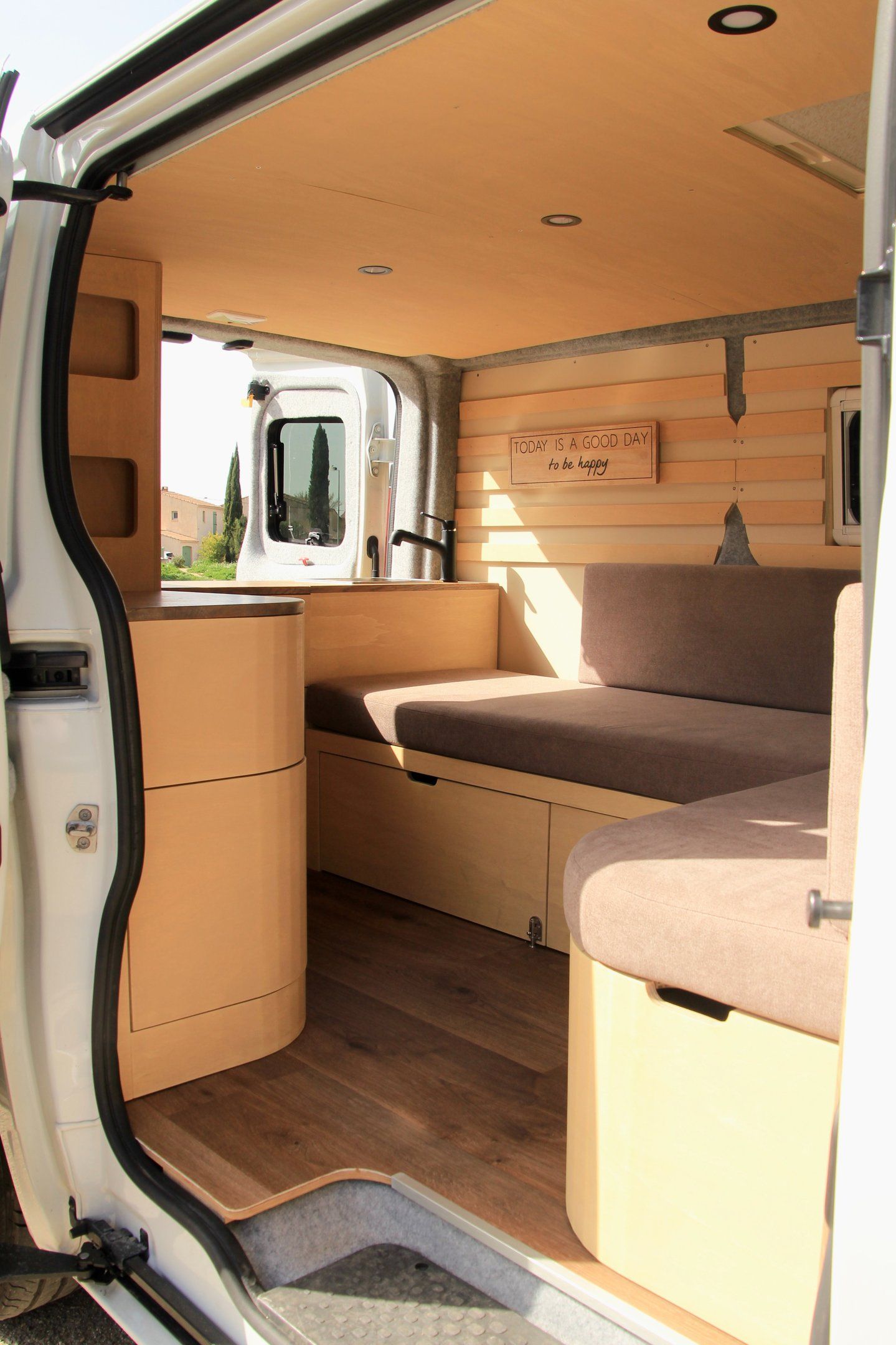 Van aménagé portes ouvertes avec couchette et matelas sur mesure, mobilier bois naturel – Mousse et Confection