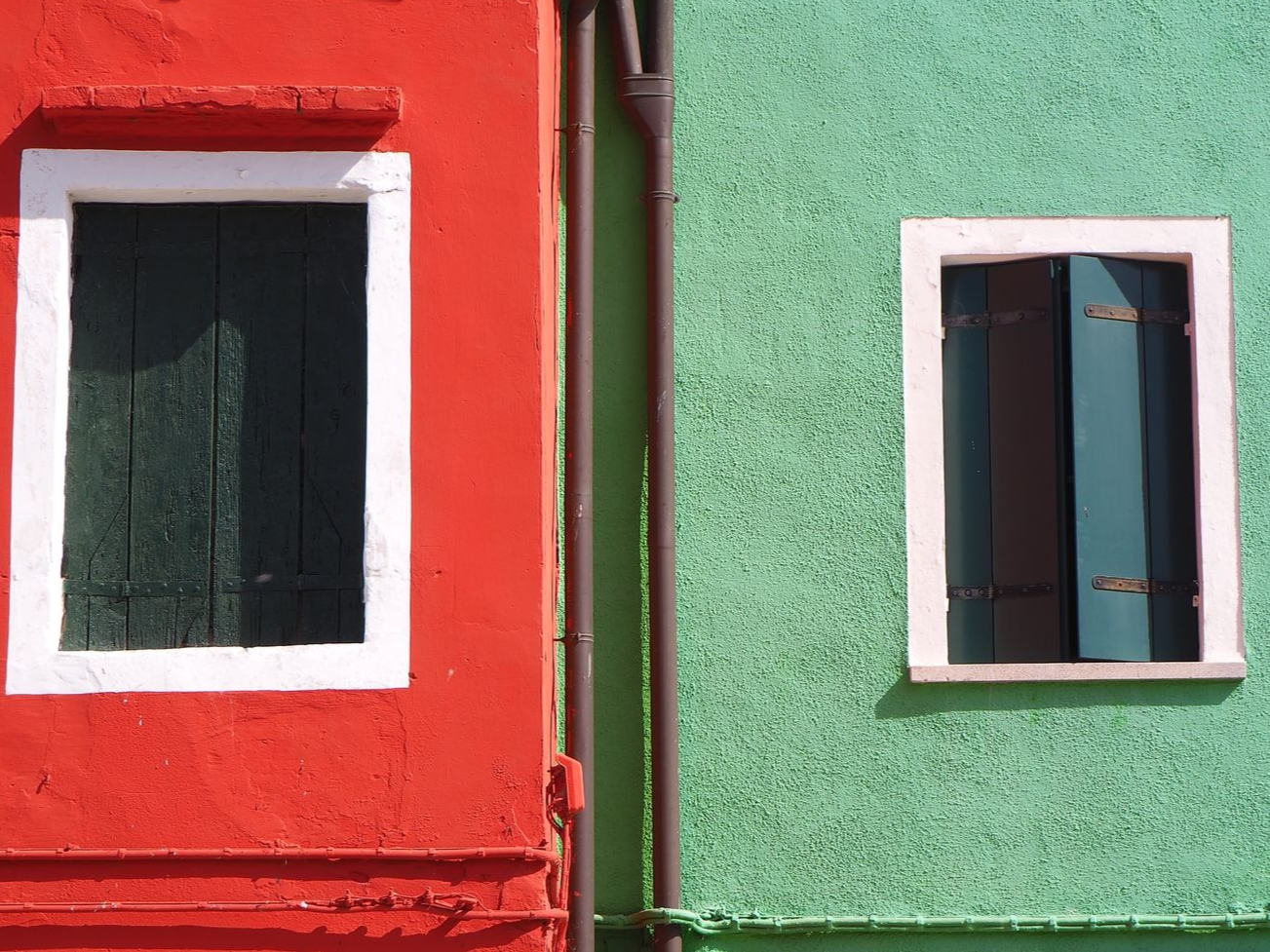 Klick zum Handy Fotokurs Motive erkennen bei Blende-16.de in der Altstadt von Nürnberg. Blende-16.de Handy Fotokurs Motive erkennen: Fassade von zwei Häusern in Rot und Grün mit zwei weißen Fenstern während einer Reise.
