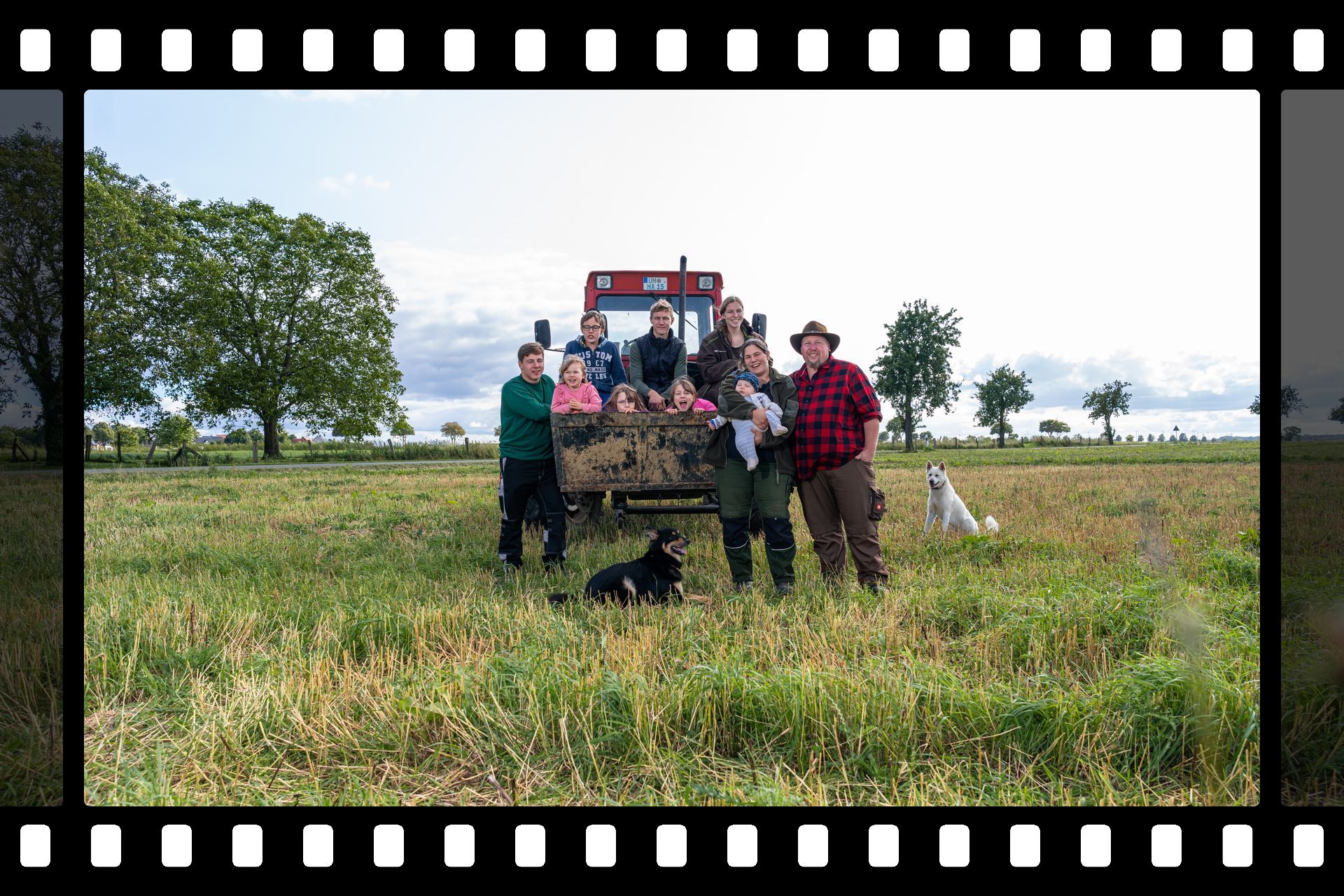Familienbild auf dem Gemüsefeld vor dem roten MB trac