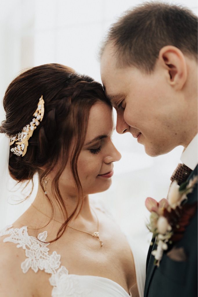 Brautpaar Stirn an Stirn, Hochzeitsmoment mit sichtbarer Brautfrisur