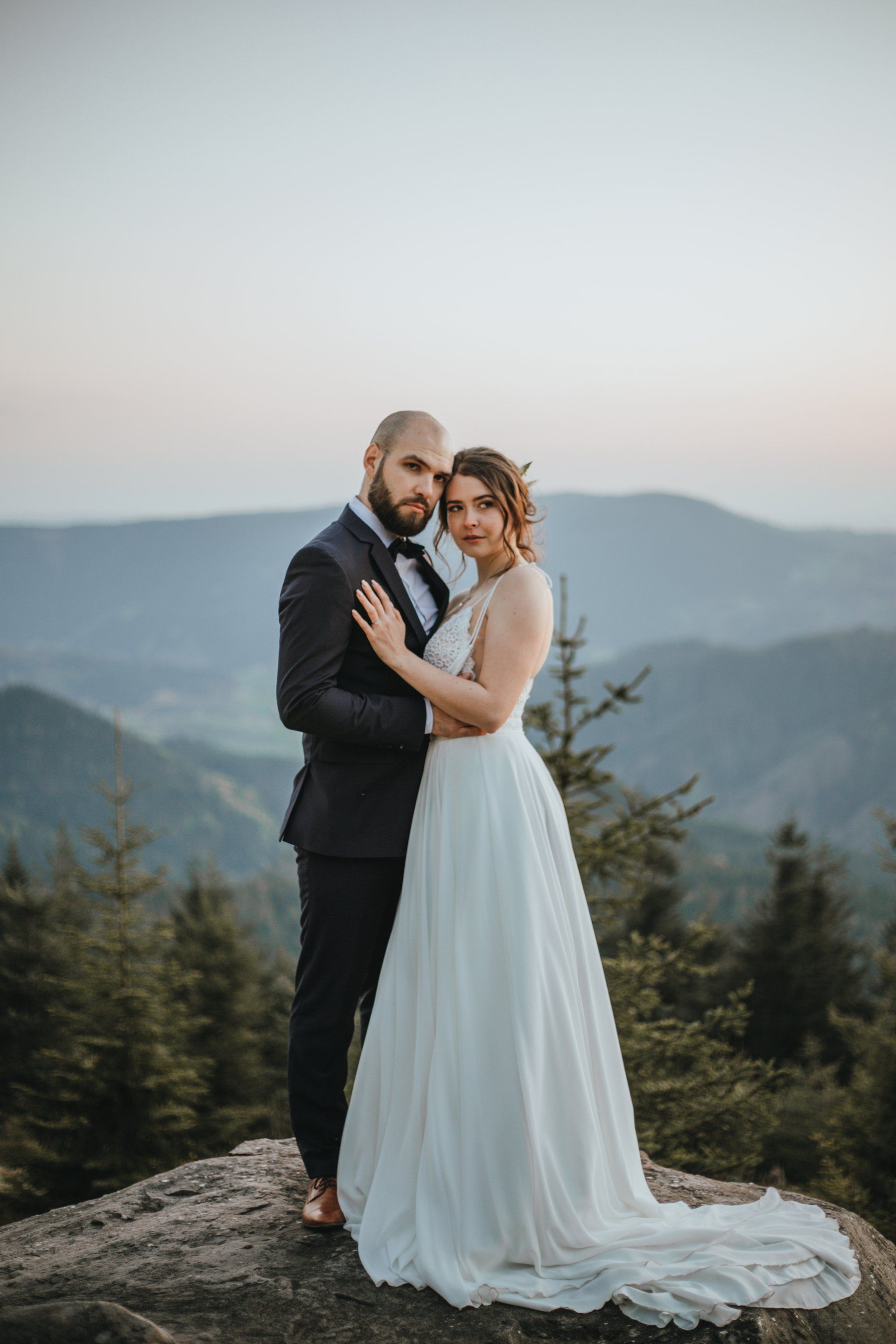 Minimalistisches Hochzeitsporträt mit Brautpaar vor weitem Himmel, ruhige Stimmung