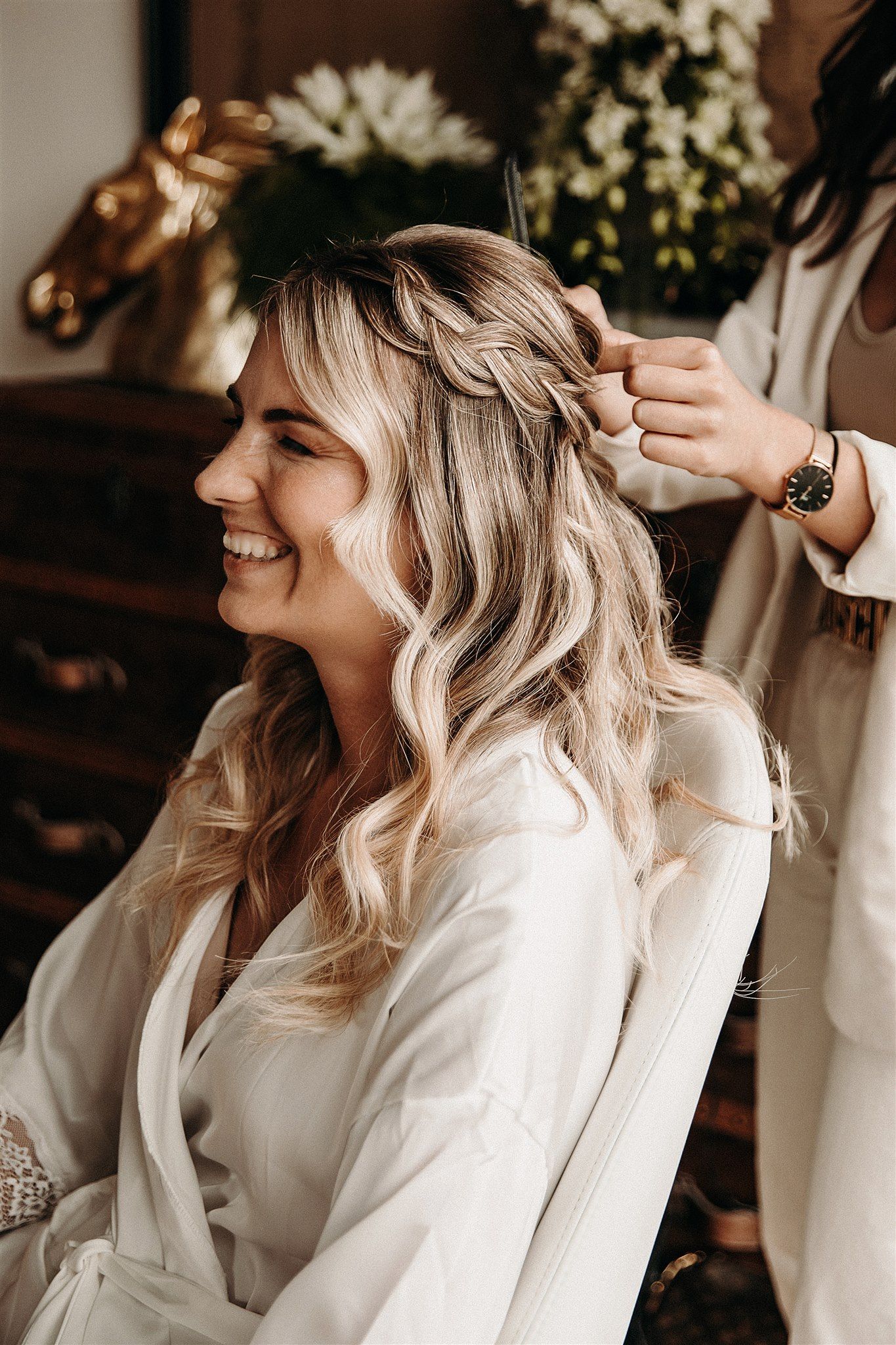 Lächelnde Braut beim Getting Ready, Haare werden zu einer Hochsteckfrisur gesteckt
