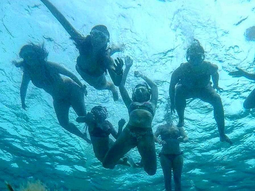Gruppo di ragazze sott'acqua con maschere da snorkeling nell'area marina protetta dell'Asinara