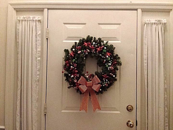 Wreath hanging on door decorated with whimsical items