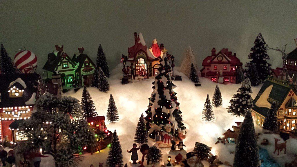 Mrs. Clause in front of the Christmas tree greeting the people who are around the town.