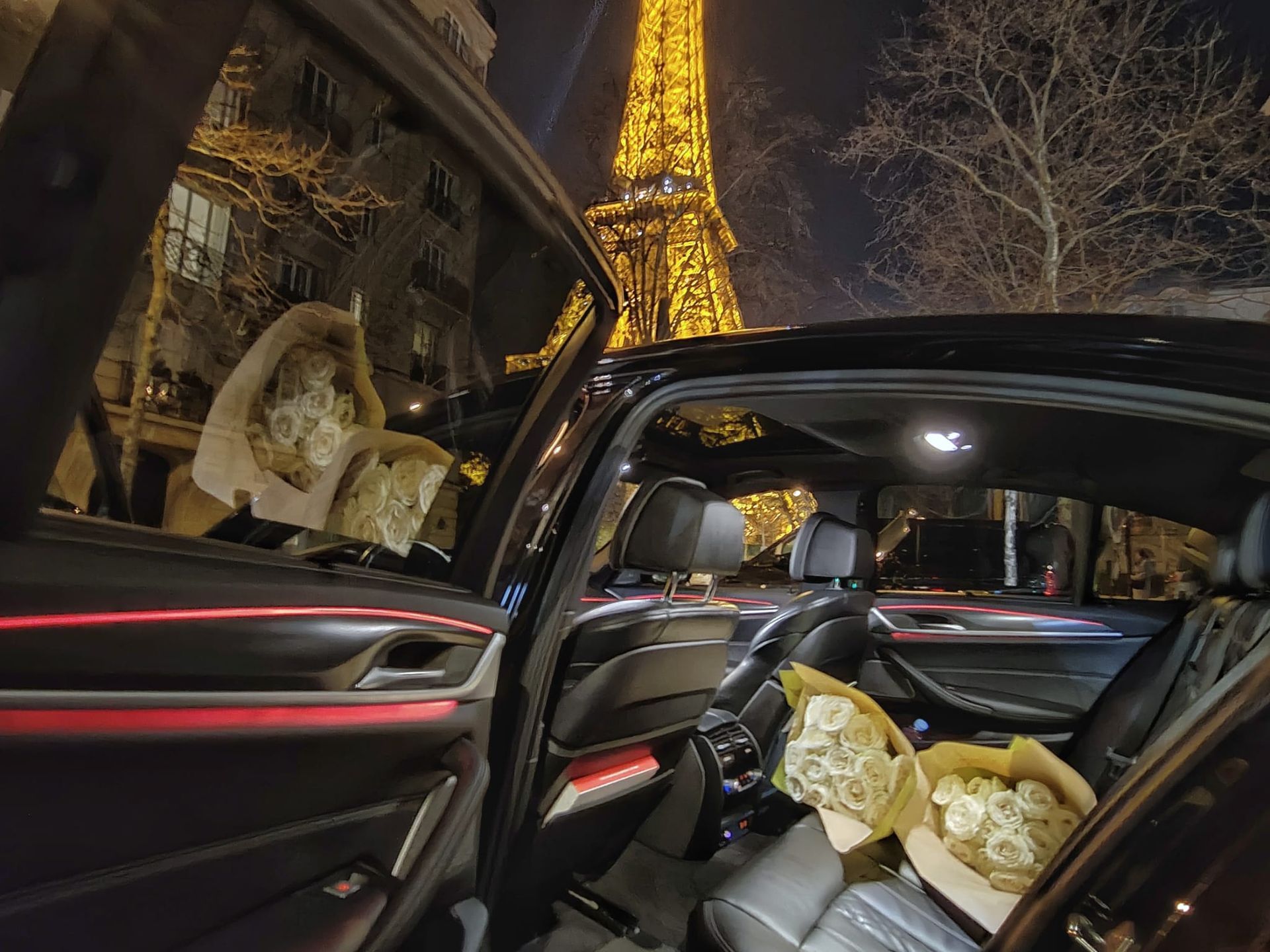 Chauffeur by the hour service in Paris with luxury sedan interior and Eiffel Tower illuminated at night