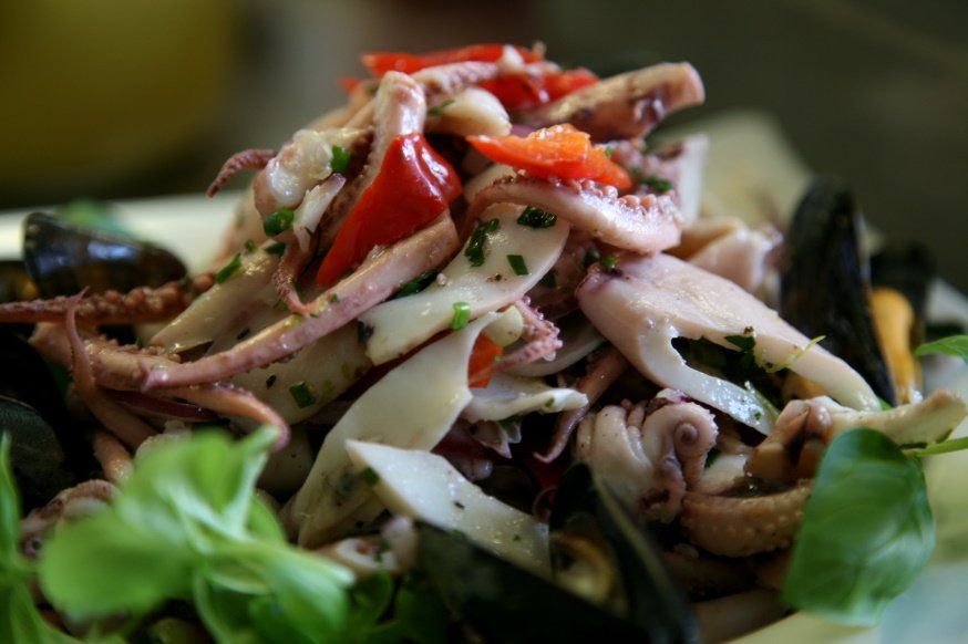 Oktopus, Sepia, Tintenfische, Miesmuscheln in einem Salat mit roter Paprika