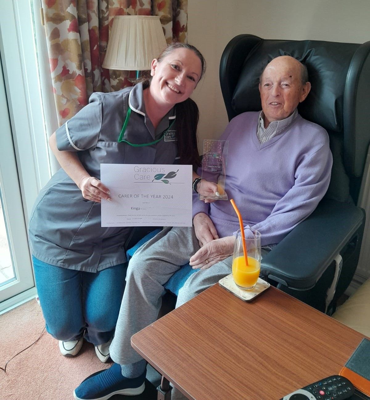 Carer presented by a customer with her 2024 Carer of the Year award