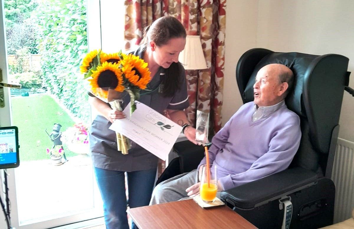 Carer presented by a customer with her 2024 Most Gracious Carer award
