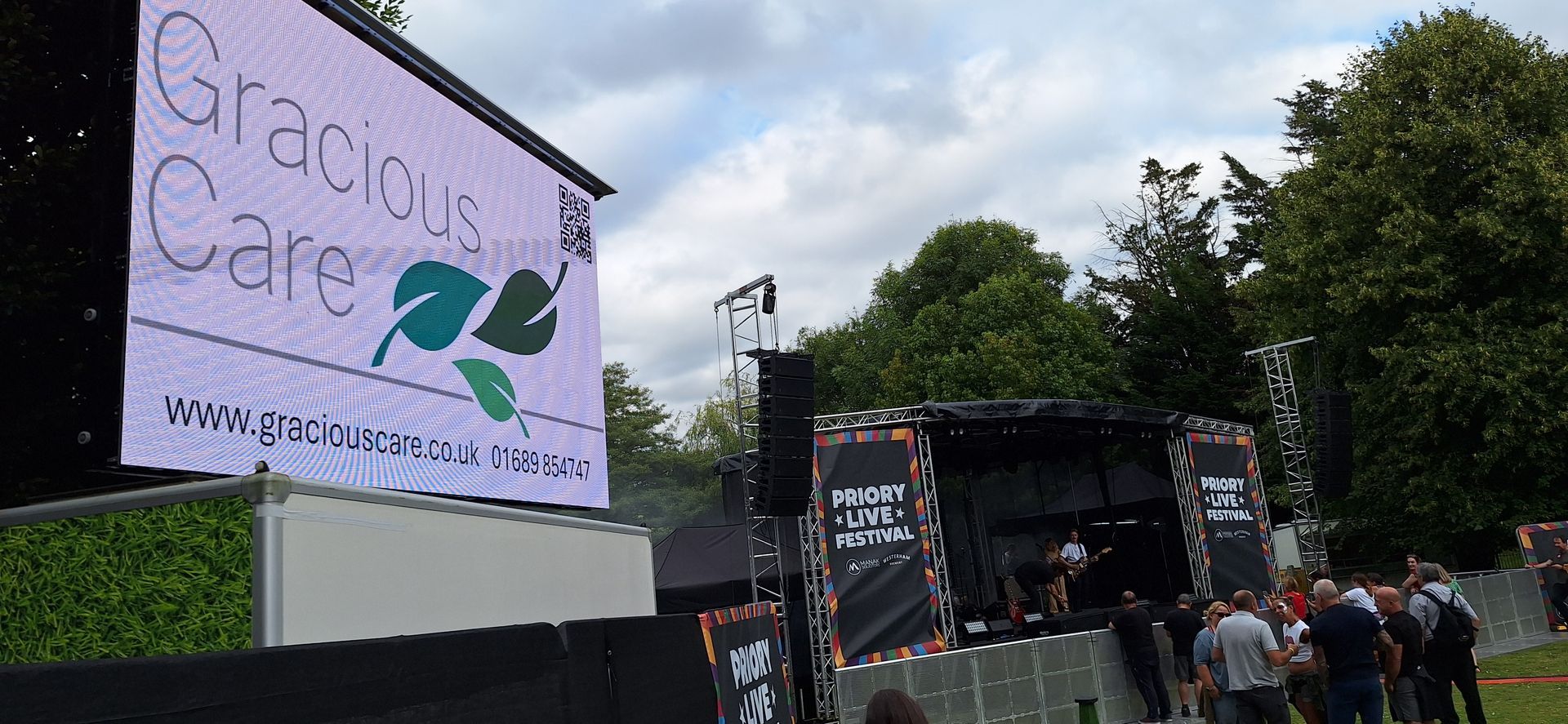 Billboard at Priory Live Concert displaying Gracious Care logo
