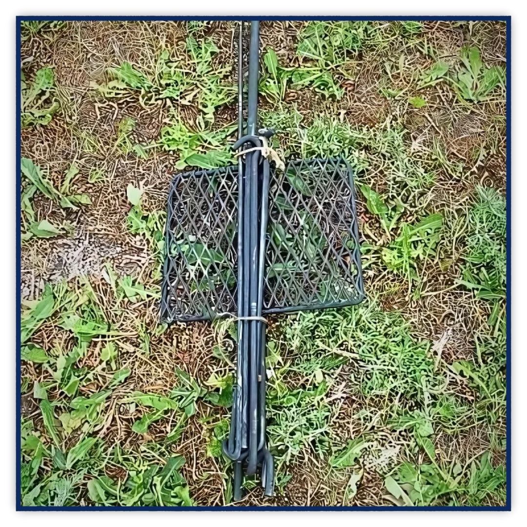 A well-seasoned, black cast iron skillet sits on a campfire grill, ready for cooking