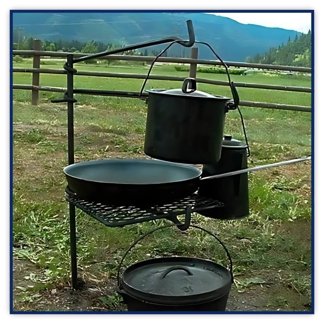 A delicious meal of steaks and vegetables cooking on a campfire grill at a rustic campsite at dusk.