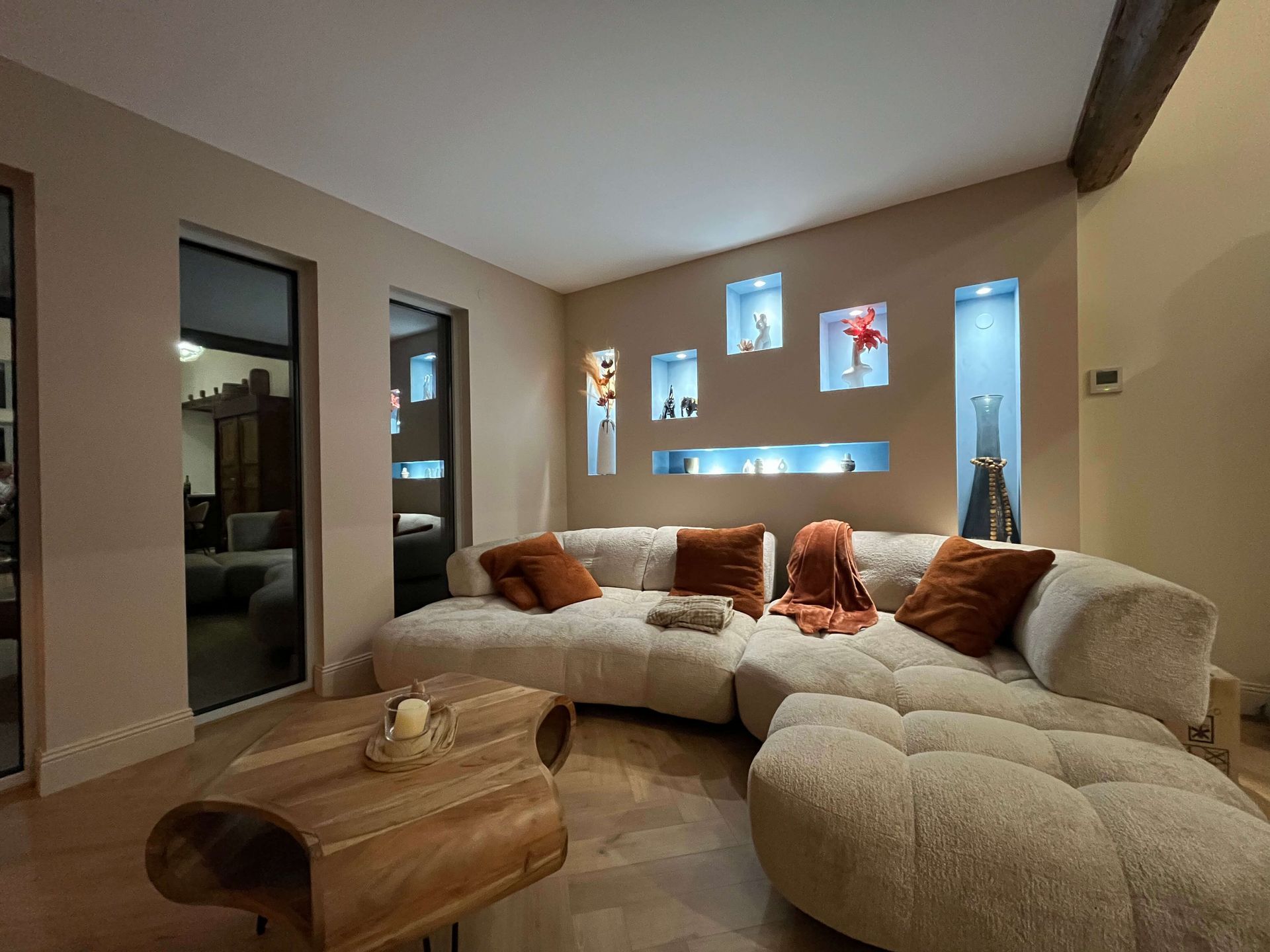 Salon rénové-niches étagères-grand canapé beige-plaid et coussins terracotta-maison proche de Charlieu-Natacha labruyere décoratrice architecte d intérieur basée a La Clayette