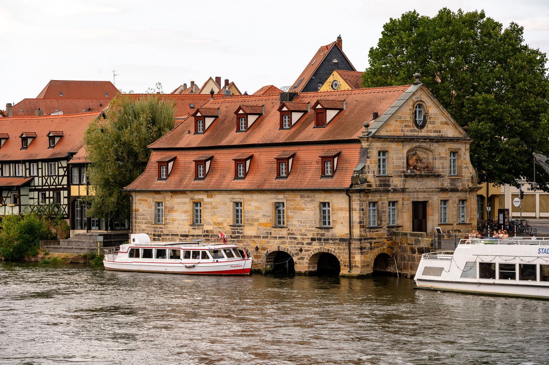 Der Alte Schlachthof in Bamberg an der Regnitz mit Ausflugsschiffen – beliebtes Motiv beim Fotowalk durch die Altstadt.