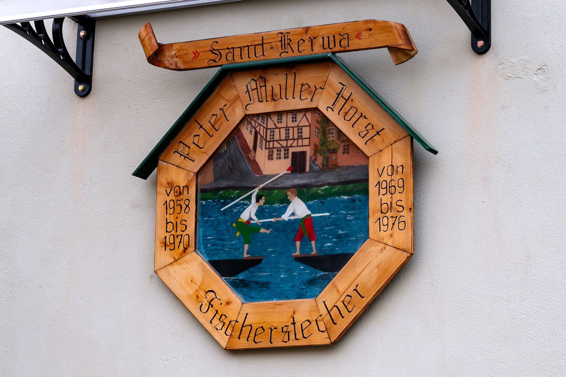 Holzschild zur Sand-Kerwa in Bamberg mit bemalter Szene zweier Fischerstecher. Detailaufnahme beim Fotowalk Bamberg.