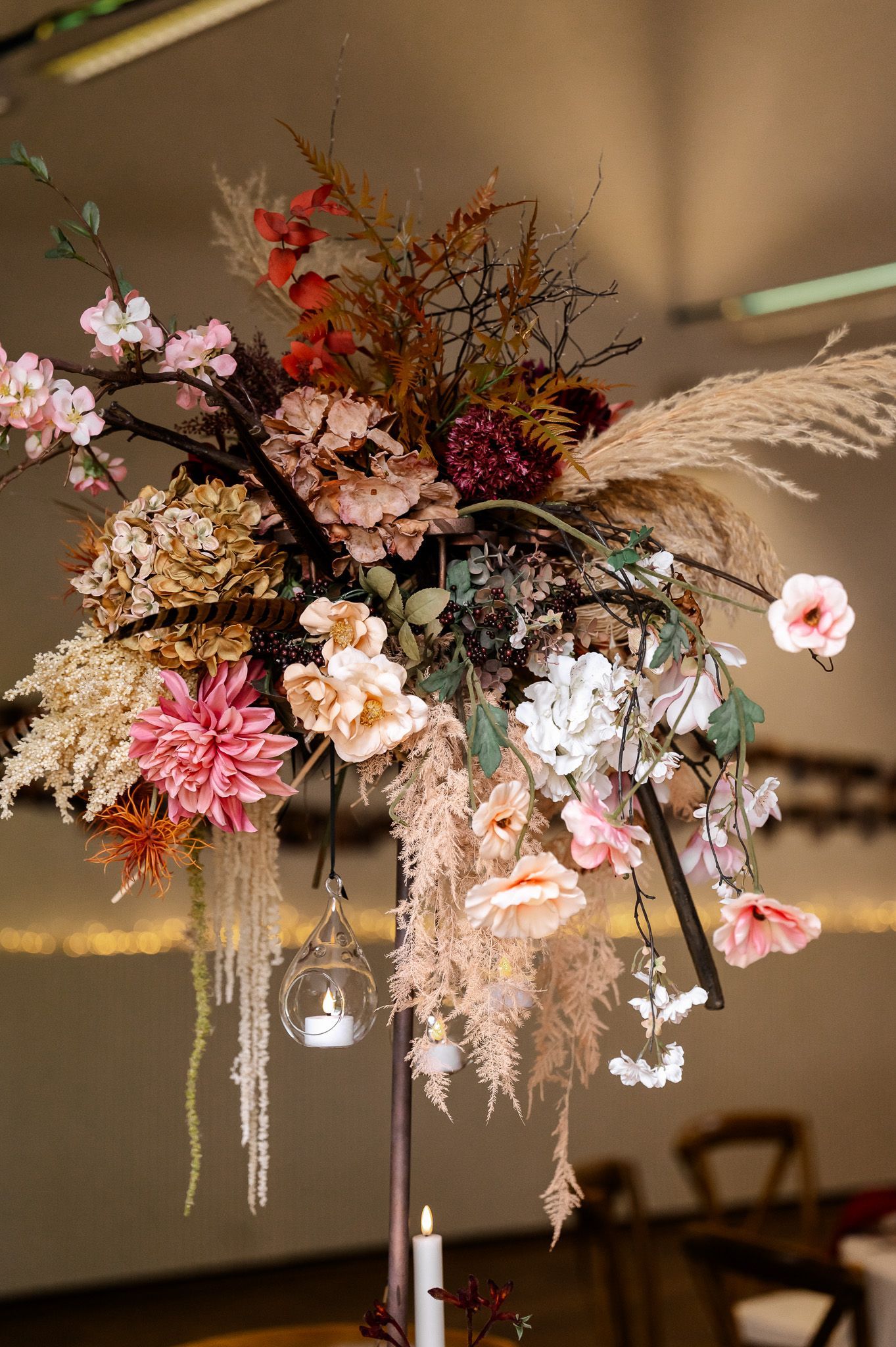 Üppige florale Hochzeitsdekoration mit Dahlien, Hortensien, Pampasgras und hängenden Teelichtern im Historik Hotel Ebrach – fotografiert von Thomas Freitag Fotografie.