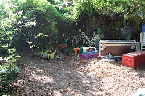 Unaufgeräumter Garten mit alten Möbeln und Gerätschaften vor der Entrümpelung.