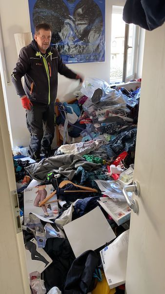 Das Schlafzimmer von einer Messi-Wohnung. Voll gefüllt mit Kleider die überall haufenweise rumliegen. Keine Ordnung im Zimmer.