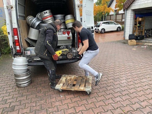 Schrott aus einer Garagenentrümpelung wird in das Fahrzeug eingeladen.