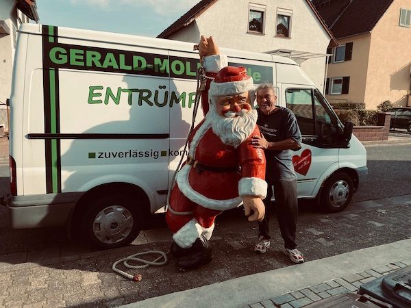 Weihnachtlicher Gruß der Entrümpelungsfirma Molitor – Santa Claus vor Molitor-Fahrzeug als Hinweis auf telefonische Erreichbarkeit zwischen Weihnachten und Neujahr.