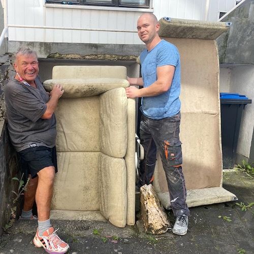 Ein verschimmeltes Ledersofa wird aus einem Keller der einen Wasserschaden hatte rausgetragen.