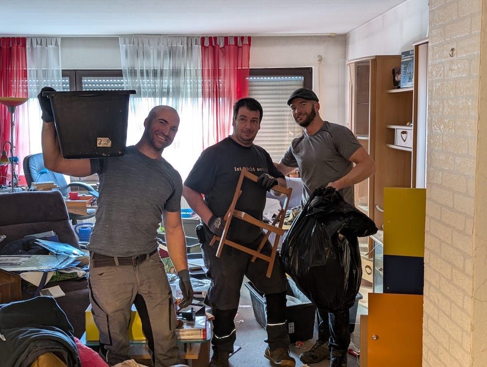 Team bei der Entrümpelung, Mitarbeiter beim Transport von Möbeln