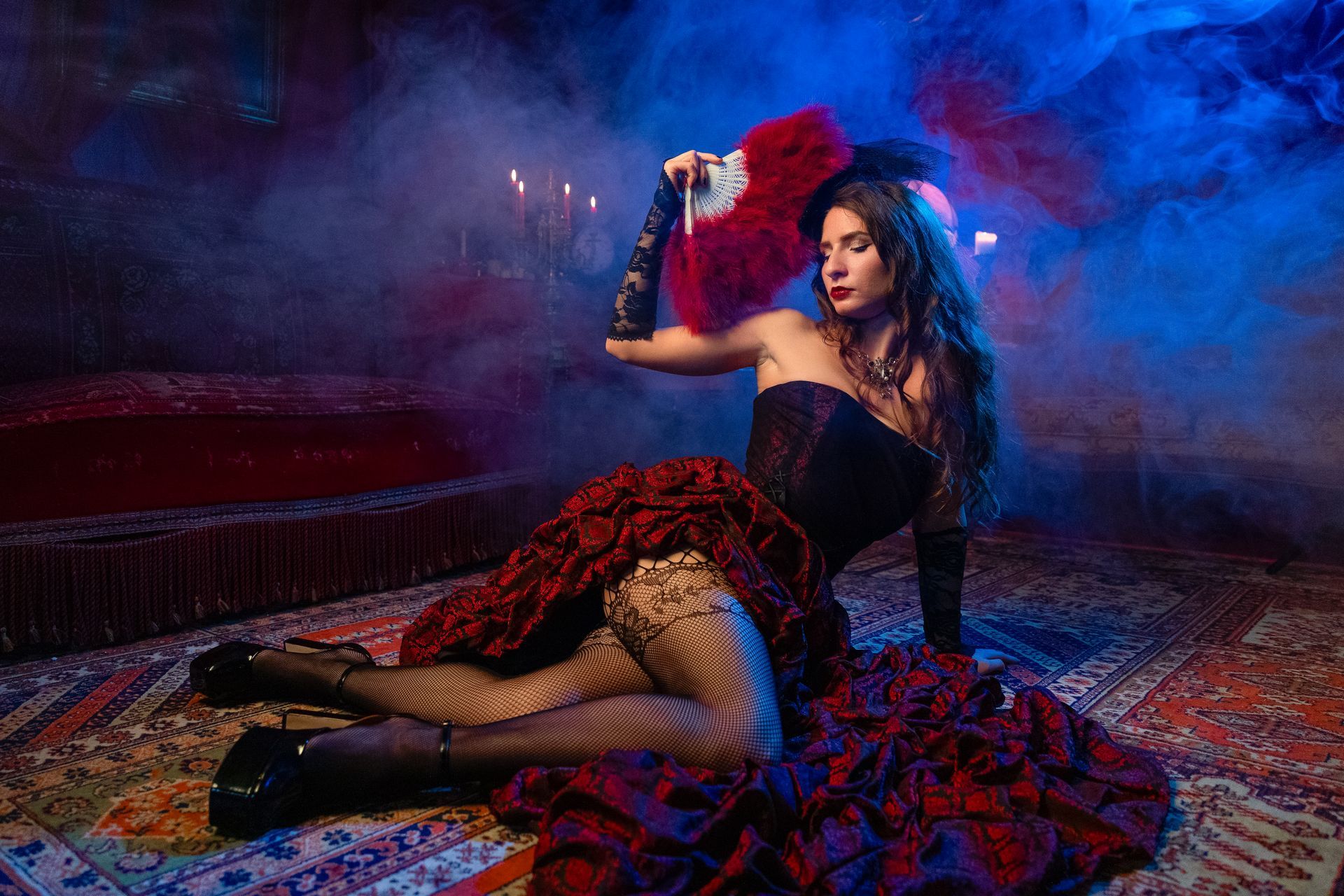 Dame in elegant schwarz Rot barock stil mit netz strumpfhose handschuhe und fächer
liegt sehr sexy auf einem roten perserteppich und schaut sehr stilvoll einher