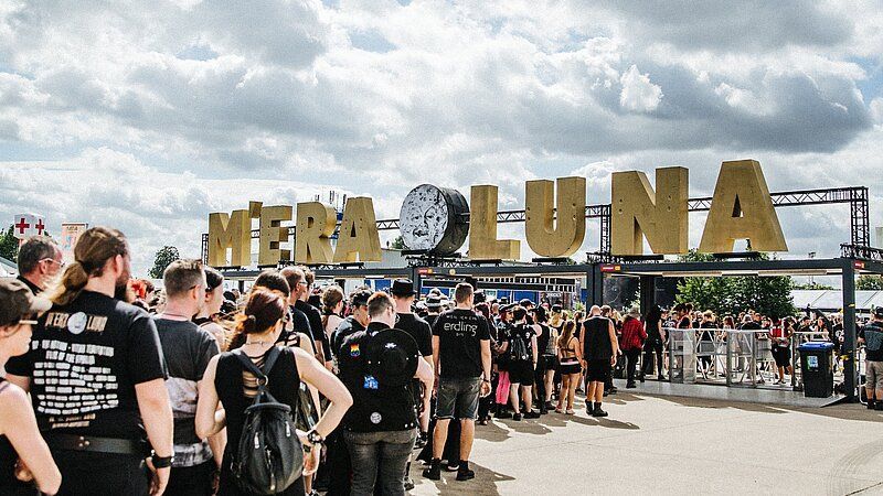 Besucherschlange am Eingang des M’era Luna Festivals 2025 mit dem ikonischen goldenen Schriftzug