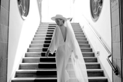 Frau im Kleid läuft die Treppe hoch und schaut zurück