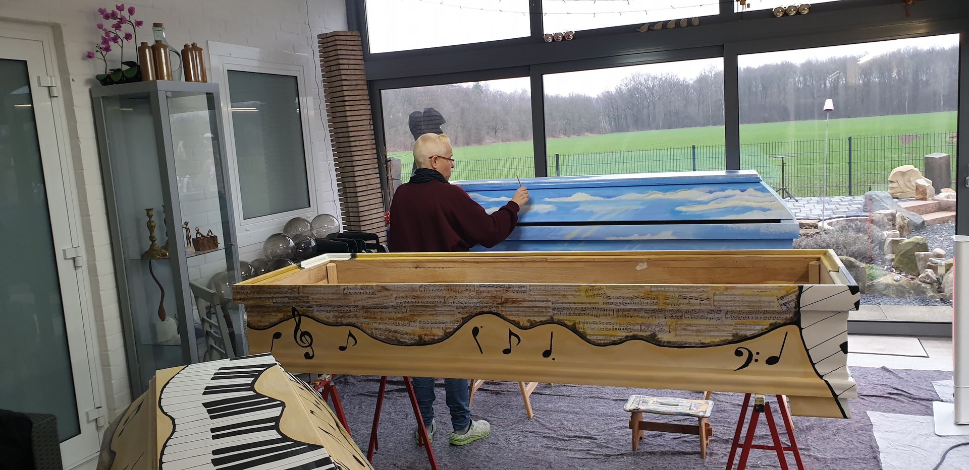 Das Bild zeigt die Künstlerin Georgia Hindenburg, aus Haste bei der Sargbemalung.