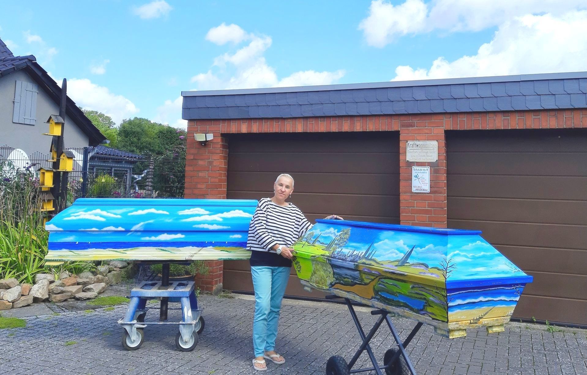 Georgia Hindenburg mit zwei von ihr bemalten Särgen