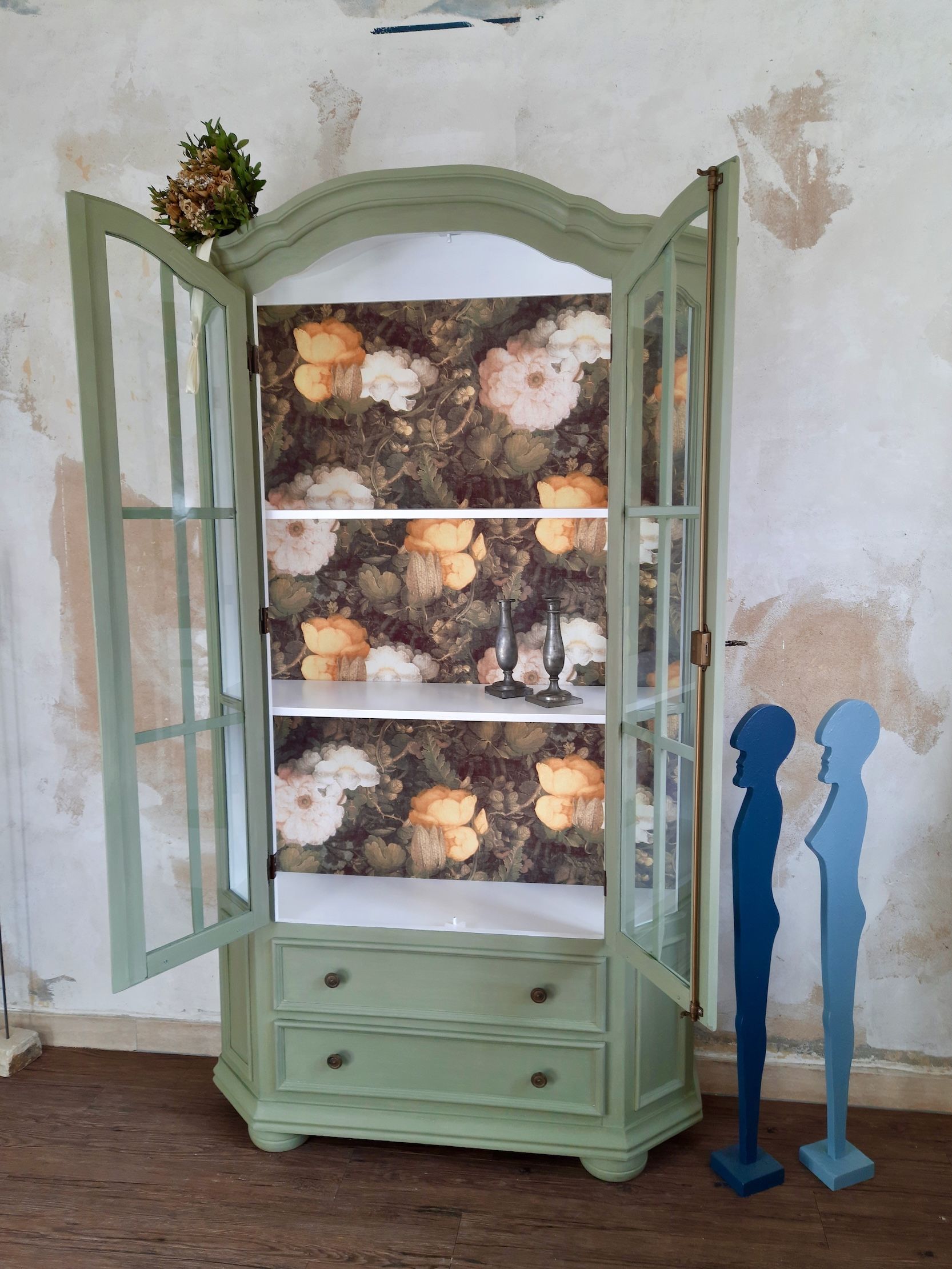 Schöne Landhaus-Vitrine mit zwei Schubladen, Oberfläche in grüner Kreidefarbe, Rückwand mit Blumentapete