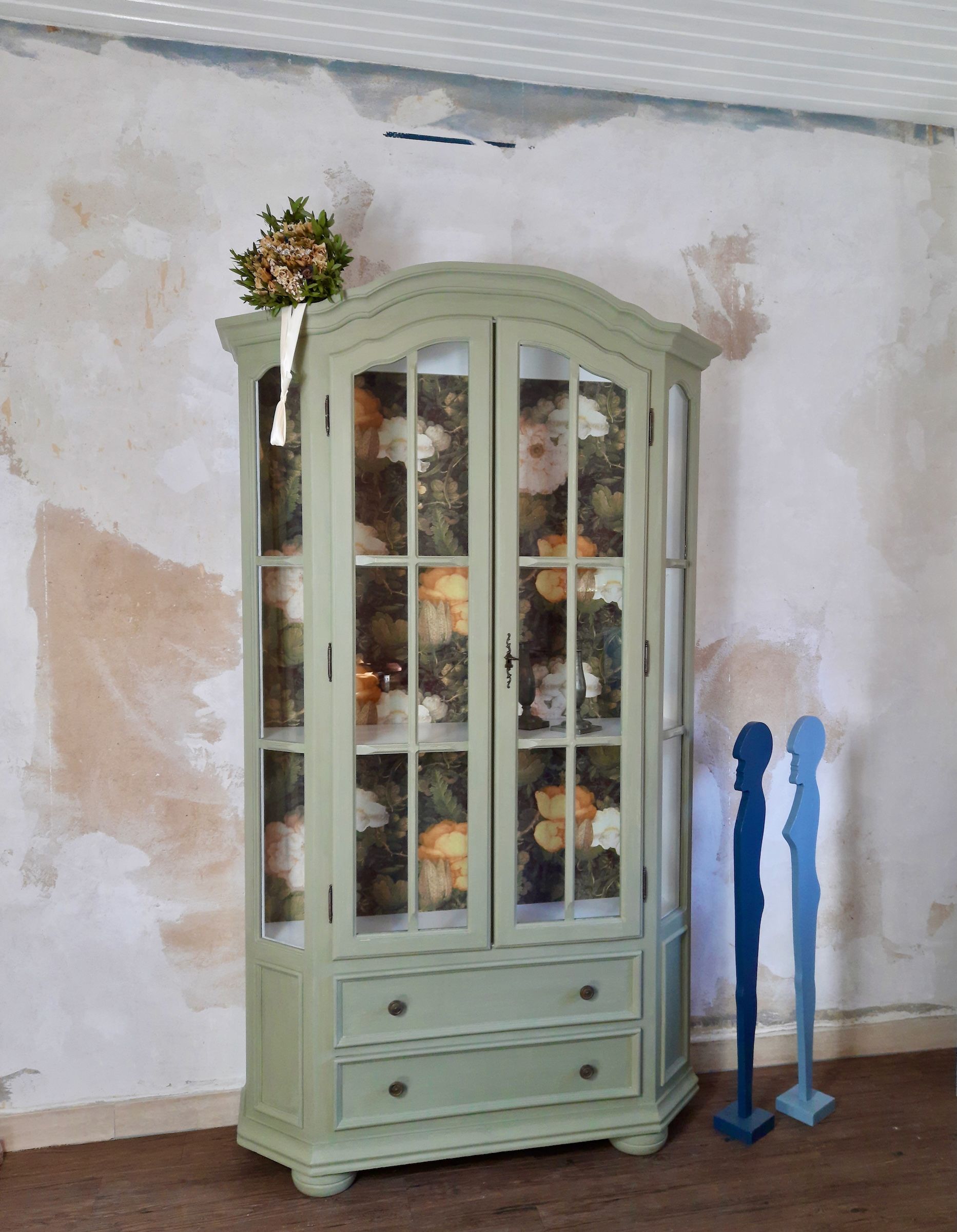 Schöne Landhaus-Vitrine mit zwei Schubladen, Oberfläche in grüner Kreidefarbe, Rückwand mit Blumentapete