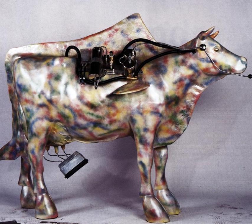 Das Bild zeigt eine gestaltete, lebensgroße Kuh-Skulptur. Oliver Pohl hat sie anlässlich der Expo 2000 in Hannover gefertigt. Sie kommt vom Jupitermond Io und trägt verschiedene Metallicfarben.