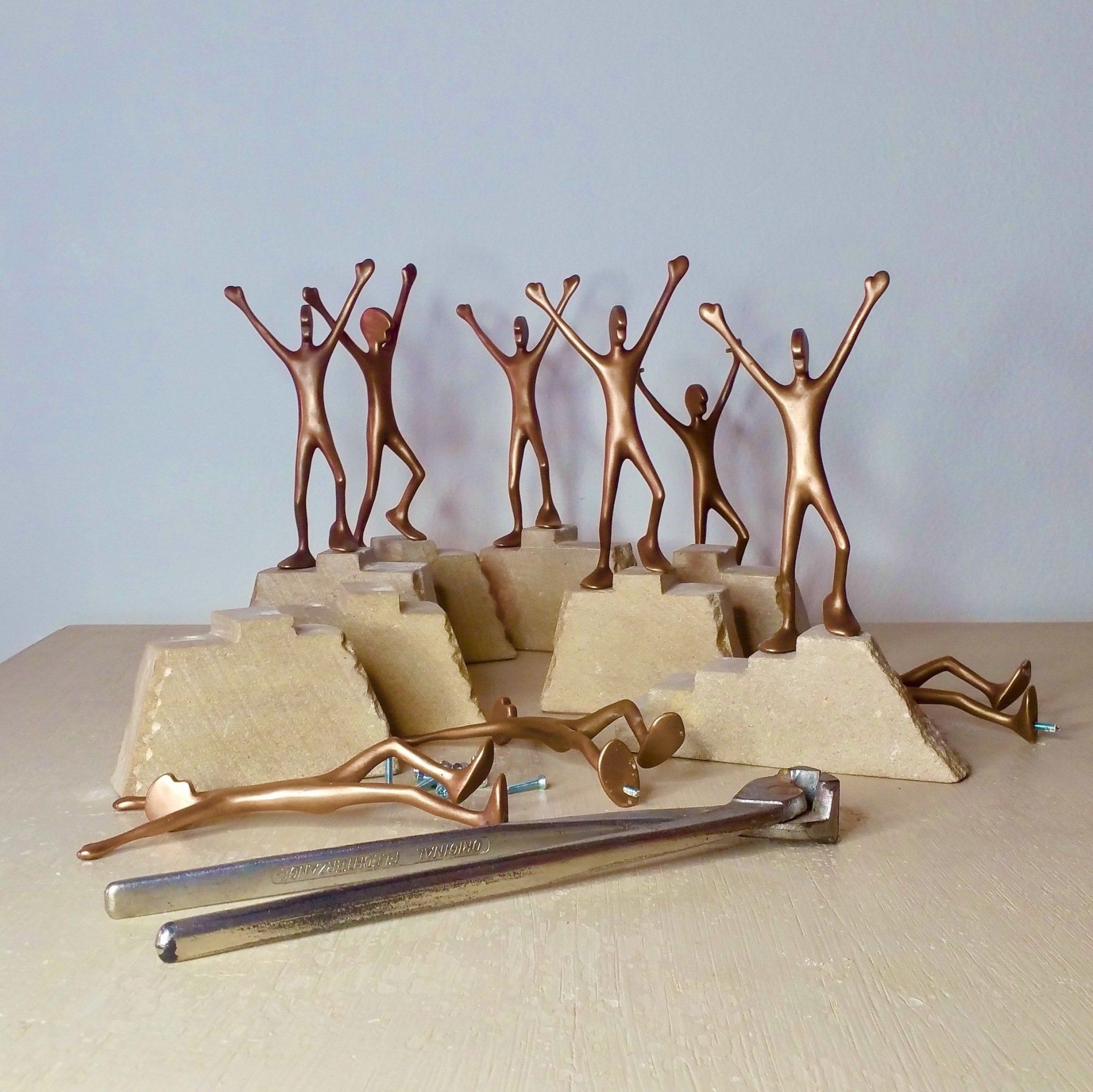 Das Bild zeigt mehrere Bronzefiguren der Serie Friends von Oliver Pohl. Sie stehen als Sieger auf kleinen Steintreppen und wurden für den Sportlerpreis der Stadt Garbsen gefertigt.