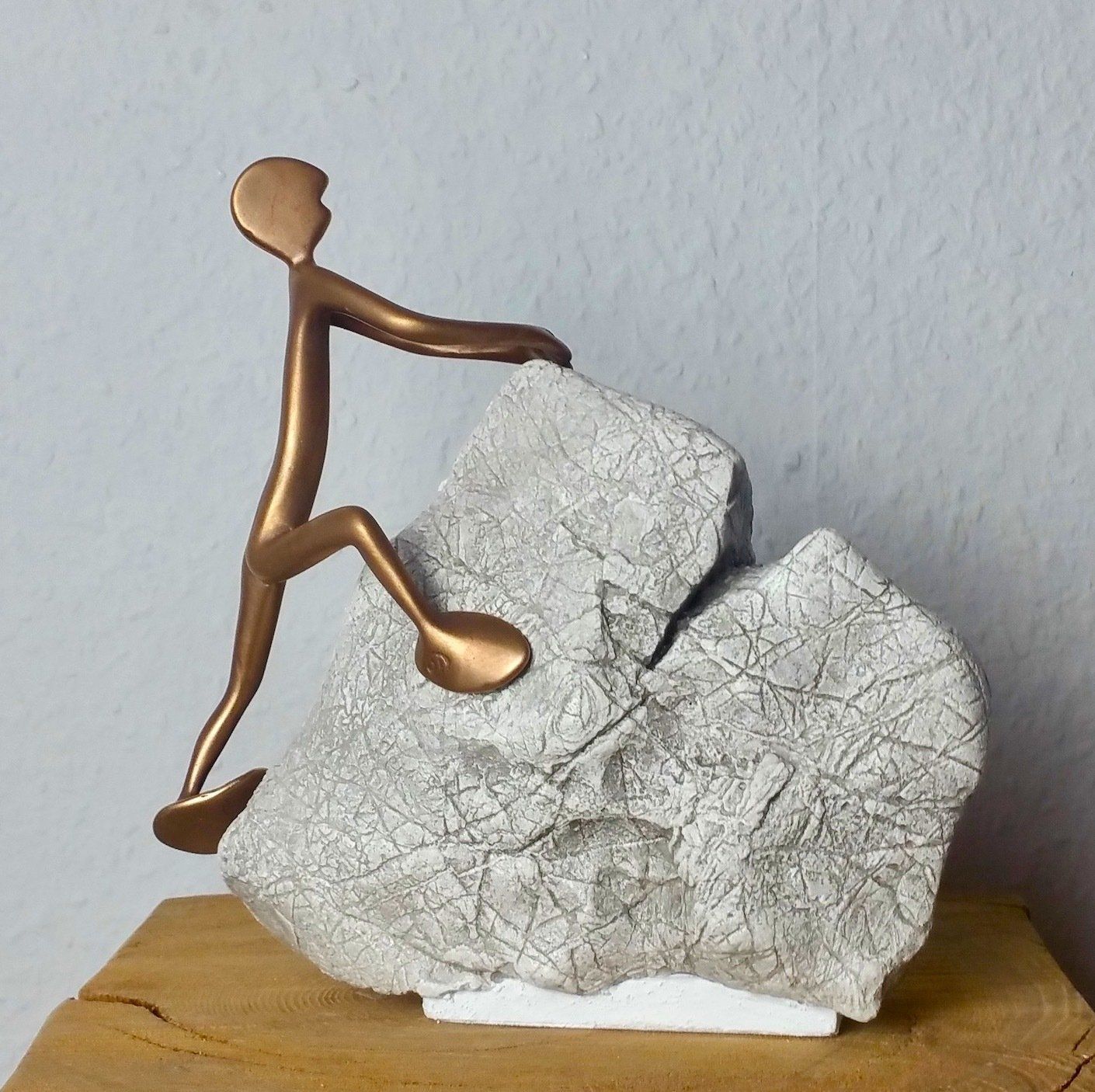 Will hoch hinaus: FRIEND No 4 Kleine Bronzefigur der Serie Friends von Bildhauer Oliver Pohl, klettert an einem Stein.