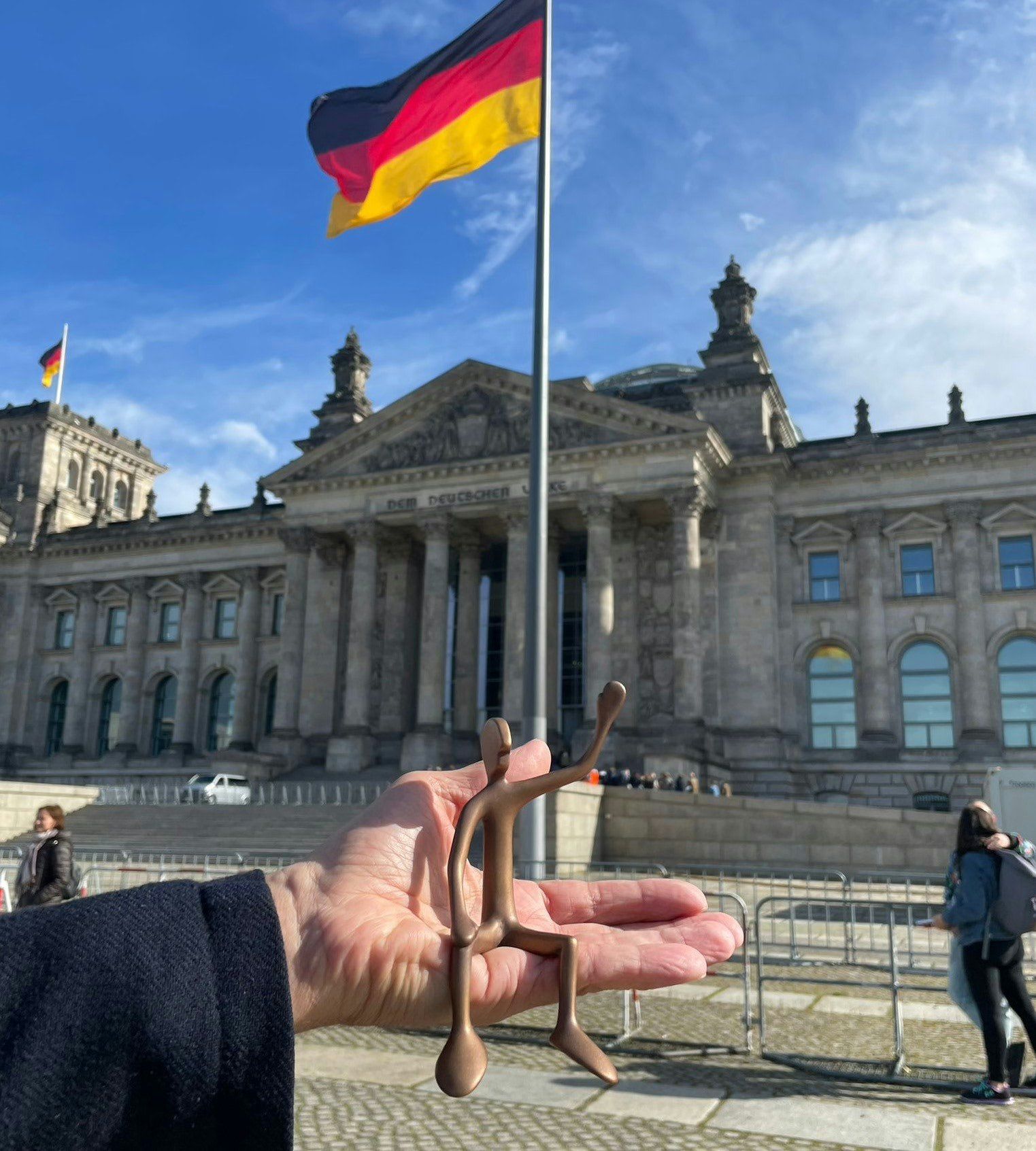 Das Bild zeigt den Bronzefreind No 2, winkend vor dem Reichstag in Berlin.
