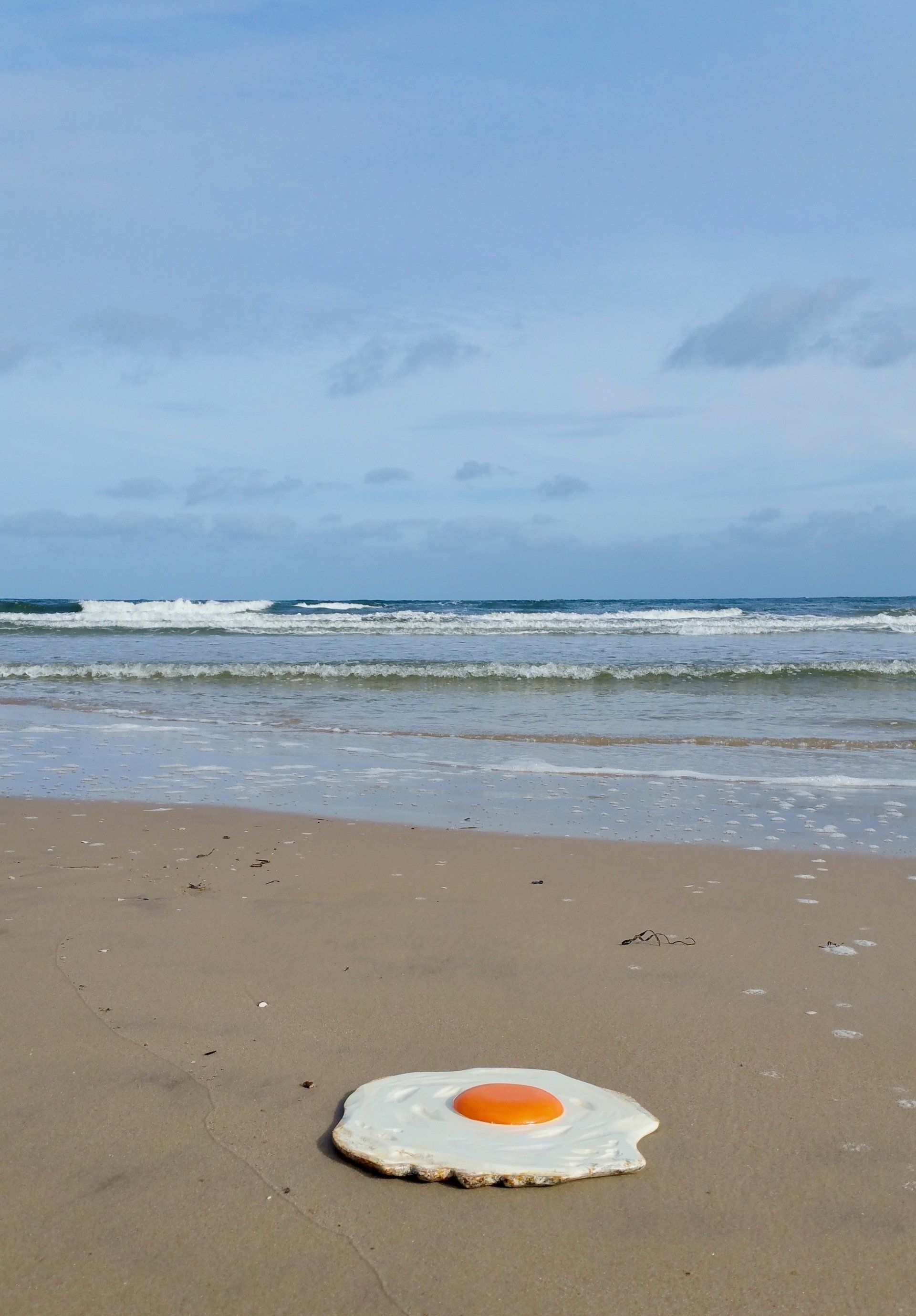 Das Bild zeigt Pop Art Spiegeleier-Skulpturen von BIldhauer und Künstler Oliver Pohl aus Haste im Schaumburger Land. Das Bild ist 2023 am Strand von Usedom entstanden.
