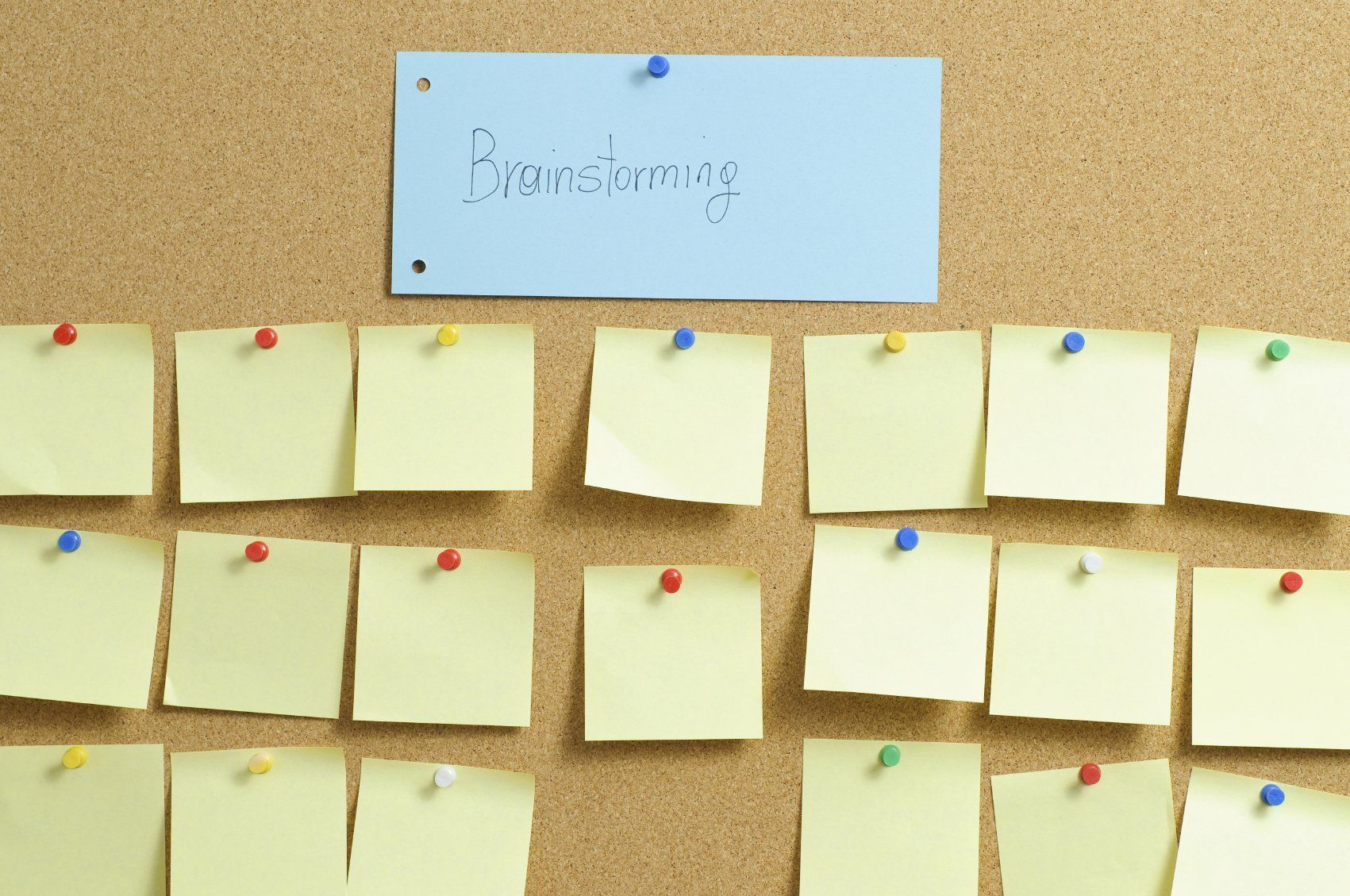 Pinwand mit Klebezetteln Pinwand mit gelben Klebezetteln. Darüber Titel: Brainstorming