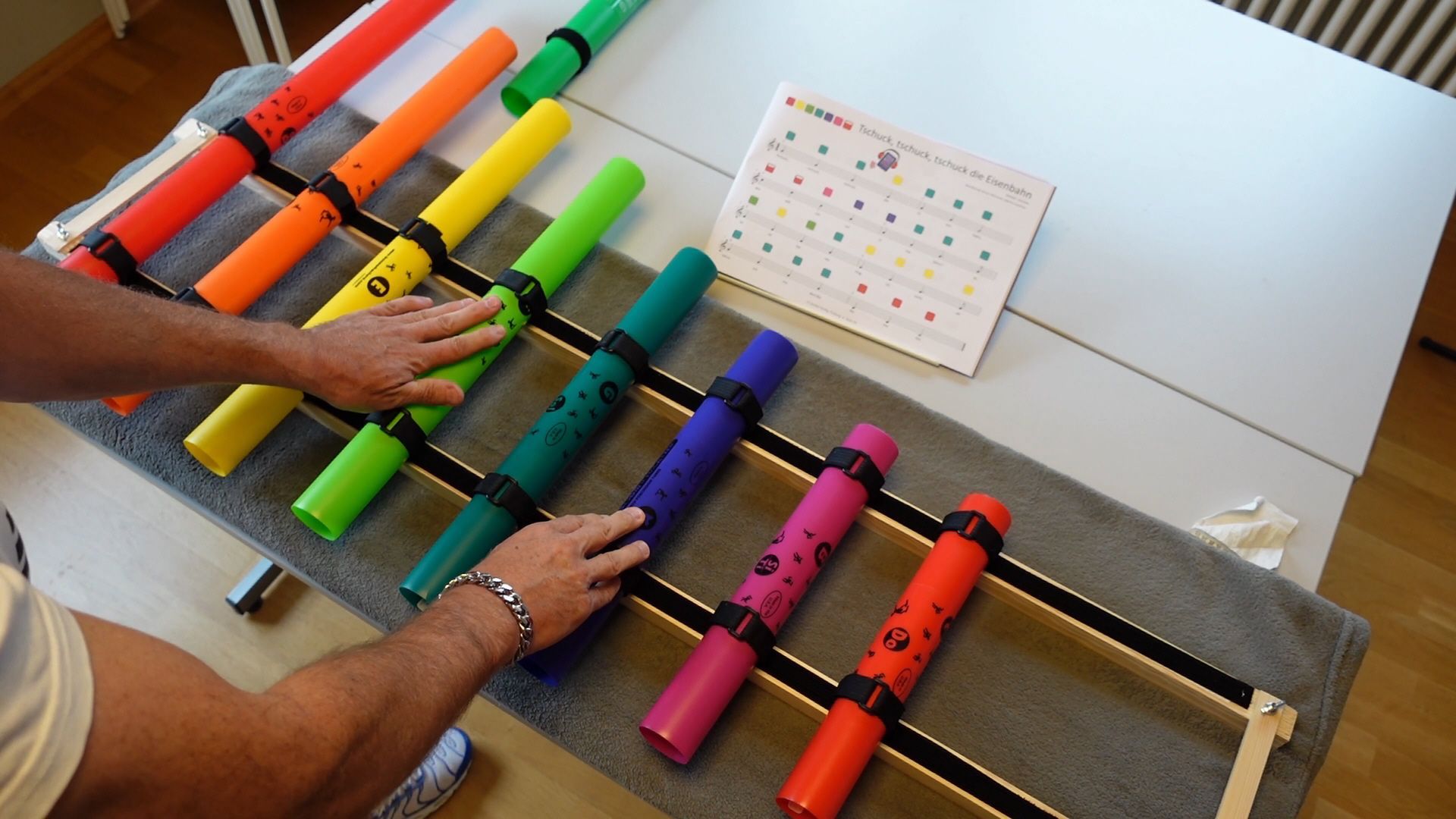 Boomwhackers® Röhren Musikinstrument Boomwhackers® sind auf einem Holzgestell mit Klett befestigt, so dass ein Melodieinstrument ähnlich einem Glockenspiel entstanden ist