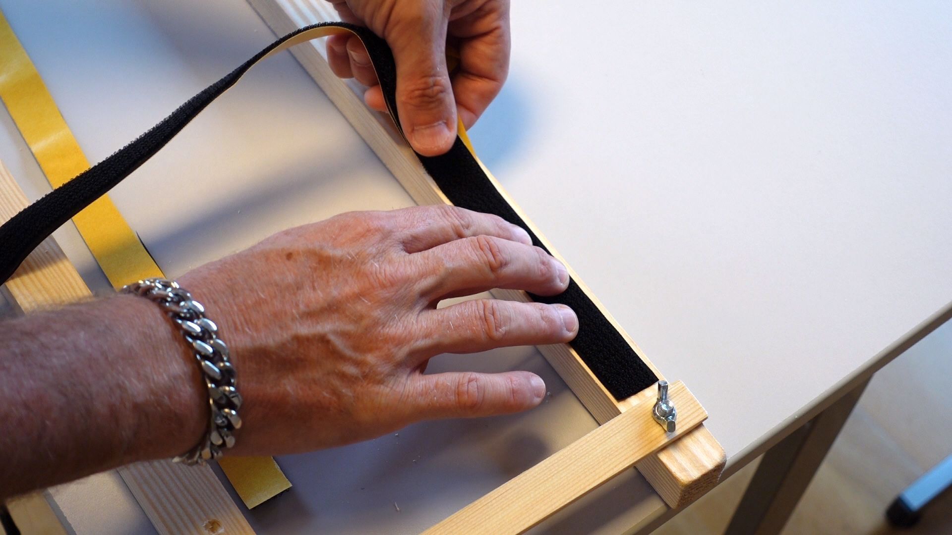 Klettband an einem Holzrahmen aufkleben, damit man später die Boomwhackers Röhren anbringen kann