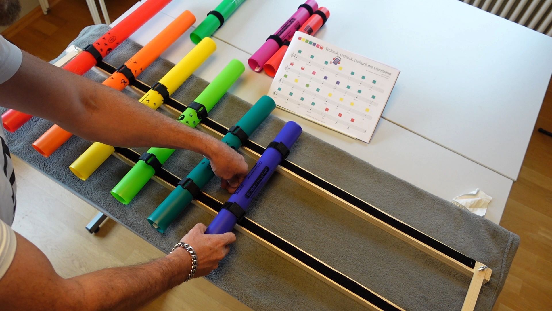 Boomwhackers Röhren werden mit Klett an einem Rahmen befestigt, so dass man Melodien in der Grundschule spielen kann